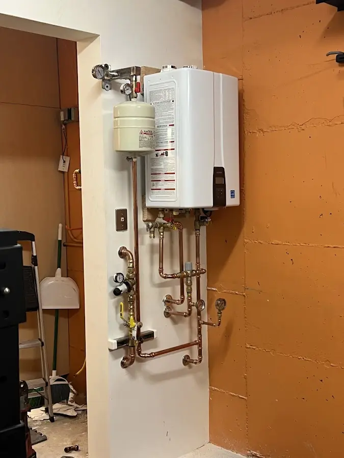 Plumbing technician inspecting water heater connections in Hokes Bluff